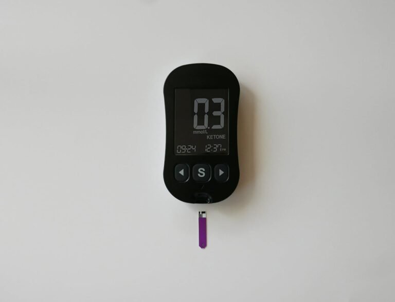 A digital blood glucose meter on a white background